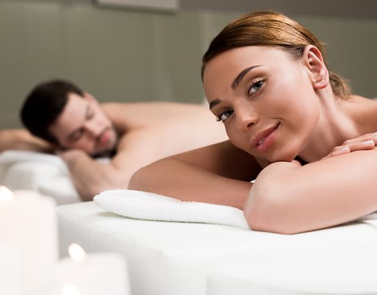 Femme souriant couché sur un lit de massage.