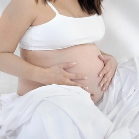 Femme enceinte. Mains sur ventre.
